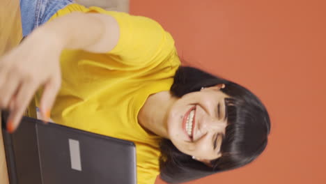 Vertical-video-of-Young-woman-joyfully-embracing-laptop.